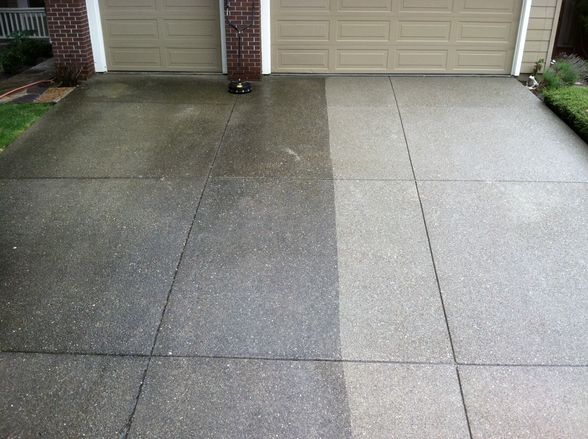 Partially sprayed driveway showing driveway cleaning services.